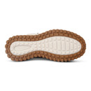 Underside of a brown winter hiking boot showing a cream and brown rubber outsole with deep multi-directional tread.
