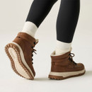 Rear view of brown hiking boots worn with white socks and black leggings, highlighting the chunky cream midsoles and rugged brown tread.