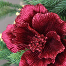 A close up view of a red glitter flower pick in a Christmas tree