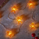 A string of cheerful gingerbread man lights glowing softly on a marble surface, adding a festive touch to the decor.