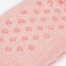 Close-up of the sole of a pink knitted lounge sock with a raised dot pattern.