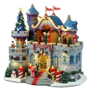 Illuminated Christmas village castle featuring Santa’s workshop, festive elves, decorated Christmas trees, candy cane accents, glowing windows and colourful holiday lights.