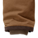 Close-up of the cuff on a brown Carhartt jacket sleeve, showing rib-knit storm cuffs layered under a reinforced outer shell.