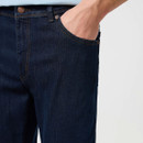 Close-up of the front pocket and waistband of dark blue denim jeans.