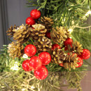 View of a red berry and pine cone pick on a wreath