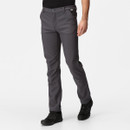 Man wearing fitted grey pants and black shoes stands on a white background. The outfit appears casual and comfortable, conveying a relaxed tone.