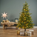 Pre-lit artificial Christmas tree displayed in a cosy festive setting with wrapped presents and warm white LED lights, creating an inviting seasonal centrepiece.