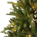 Close-up of realistic artificial Christmas tree branches featuring warm white LED lights woven through dense green pine needles for a natural evergreen appearance.
