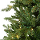 Close-up of an artificial Christmas tree branch with warm white lights on a white background.
