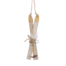 A hanging decoration of two small wooden skis slightly crossed over, with skiing poles wrapped in a brown string bow and two bells attached.