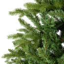 Close-up of realistic artificial Christmas tree branches featuring dense green pine needles and lifelike mixed-tip foliage.