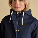 Close-up of the hood and neckline of a navy waterproof jacket, showing white drawcords with gold ends and a high-collar zip fastening.