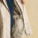 Interior view of the beige raincoat showing checked lining and an inner pocket with Joules branding.