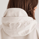 Close-up of jacket hood in light beige fabric with structured seams and soft faux-fur lining.