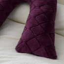 A purple textured v-shaped cushion against a soft white background.