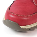 Close-up of red ankle boot toe showing smooth synthetic leather upper, double stitched detailing, and contrasting grey outsole with cream midsole trim.