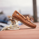 A walnut brown deck shoe, propped up on a mooring point with rope coiled around it A walnut brown deck shoe, propped up on a mooring point with rope coiled around it