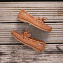 A pair of walnut brown deck shoes on a wooden pier A pair of walnut brown deck shoes on a wooden pier