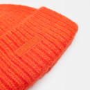 Close up view of an orange wool hat on a white background