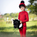 A child wearing all red with a black and white hobby horse