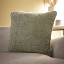 A green coloured cushion on a sofa