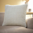 A ivory coloured cushion on a sofa
