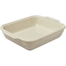 A beige ceramic baking dish on a plain background.