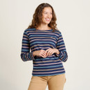 A close up of a woman wearing a long sleeve navy striped top with beige trousers.