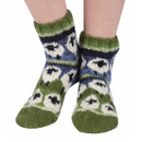 A close up of someone wearing knitted socks with sheep on.