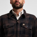 Close-up of a dark brown and black checked fleece overshirt featuring a collar, button fastening and two flap chest pockets.