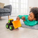 A child playing with a yellow and black JCB Dougie dump truck toy in their living room.