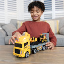 A child playing with the JCB transporter vehicle on a coffee table.
