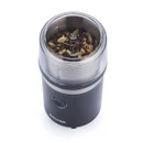 Electric coffee grinder with spices inside, isolated on white background.