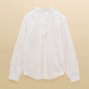 A white long-sleeve frill-neck blouse displayed flat to show its relaxed shape, ruffled neckline and soft cotton fabric texture.