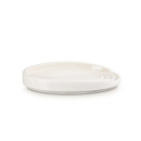 A cream spoon rest with rings aorund the edge.