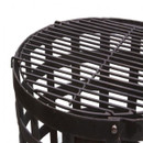 Black round grill top on a fire basket viewed from an angle against a white background.