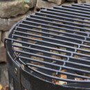 Close-up of a round metal grill grate over a fire basket.