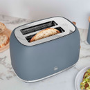 Close-up of the Swan Fjord toaster with seeded bread in the wide slots, highlighting the stainless steel interior and premium finish.