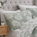 A green pillowcase with white chrysanthemum florals.