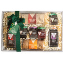 Gift box with a green bow, containing assorted crackers and jars of chutneys in vibrant labels, laid on straw. Festive and inviting presentation.