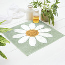 A teal shower mat with a flower.