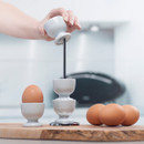 A stack of light blue egg cups being stacked on a chrome stand.