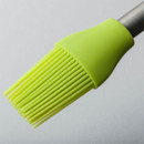 Close-up of a lime green silicone pastry brush with a metal handle on a white background.