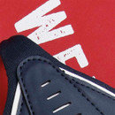 Close-up of a navy athletic shoe with white accents and perforated details, set against a red background with white text.