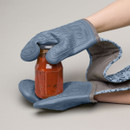 A pair of hands wearing silicone oven gloves opening a jar of sauce.