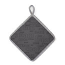 Dark grey square trivet with cooking-related words on a white background.