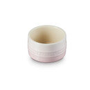 A light pink ramekin with Le Creuset branding