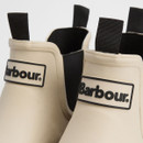 A close up view of the black Barbour logos at the front and the black pull tabs.