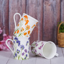 Three stacked ceramic mugs with floral patterns against a rustic wooden backdrop.