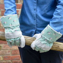 Someone holding a wooden post wearing garden gloves with a posies design